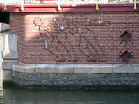 850556 Afbeelding van het baksteenreliëf met twee jagers die een schip trekken, op het bruggenhoofd van de Stenenbrug ...